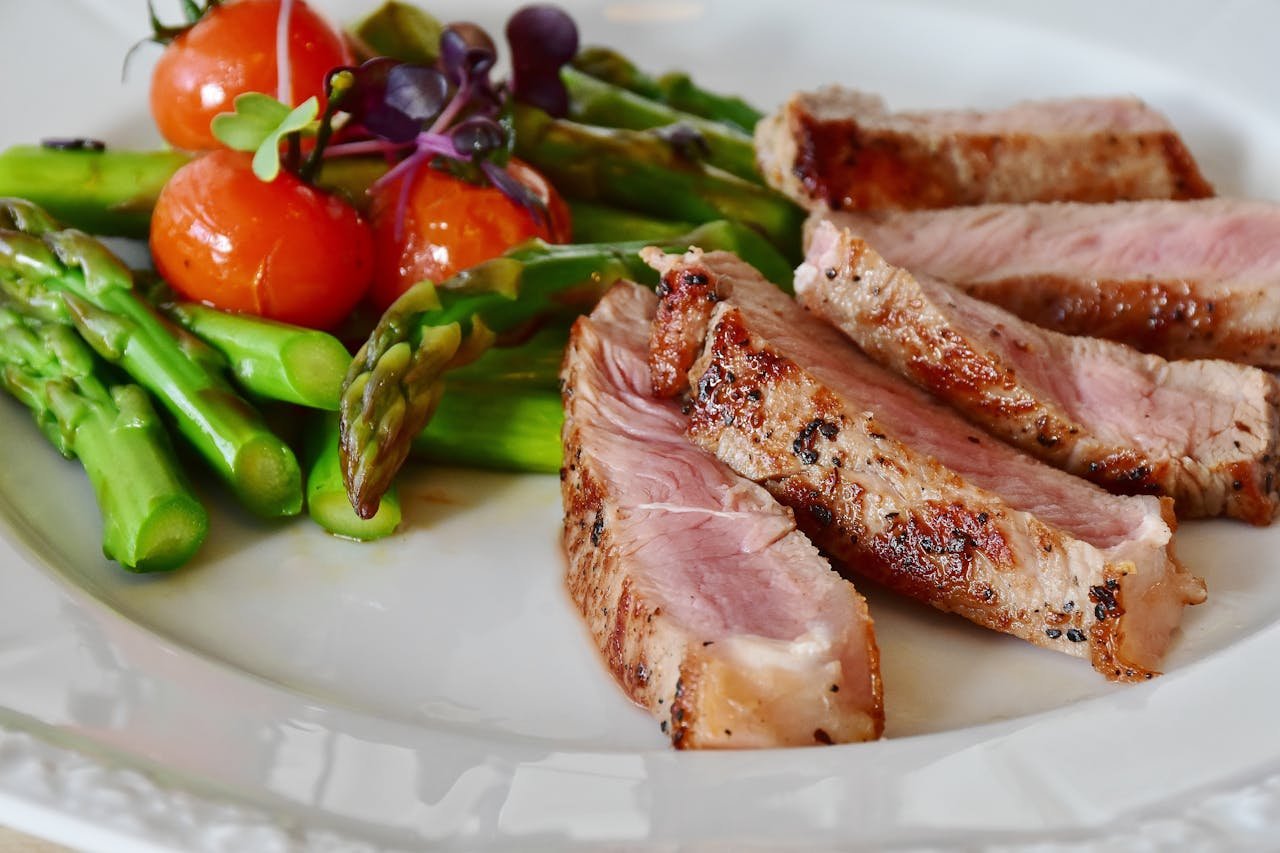 The Art of Drawing Readers In: Your attractive post title goes here Close-up of grilled steak slices with asparagus and cherry tomatoes, perfect for a healthy meal.