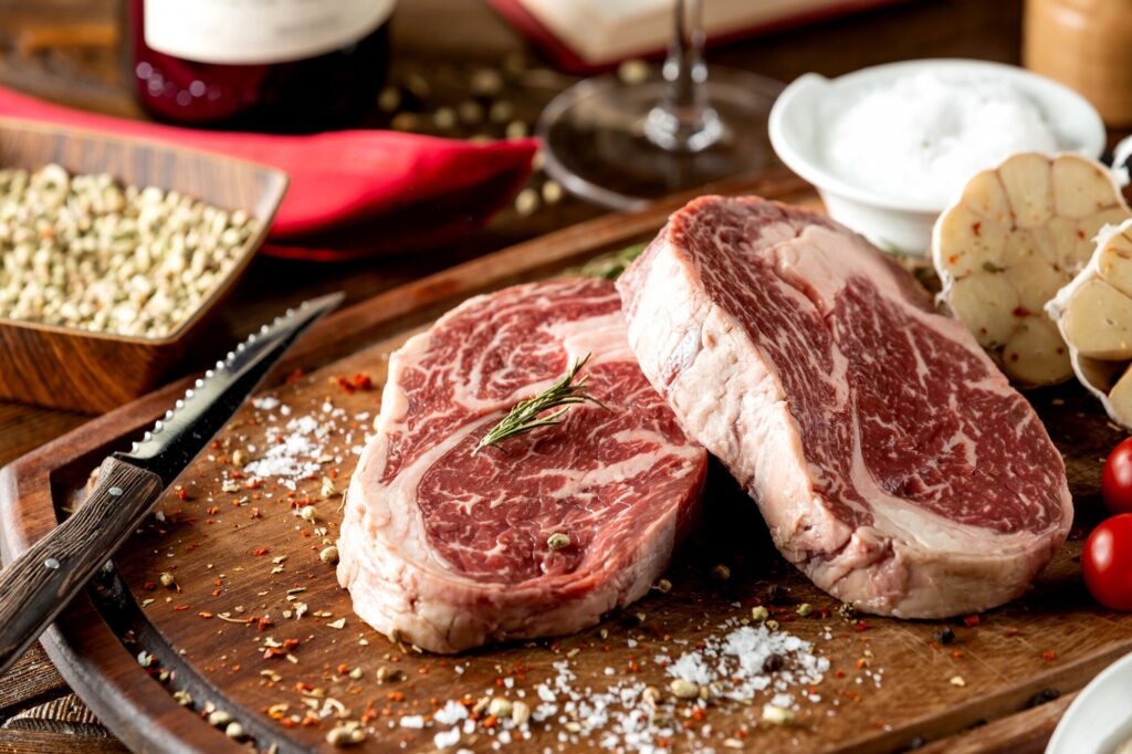 close up raw steak pieces garnished with salt herbs 140725 4990
